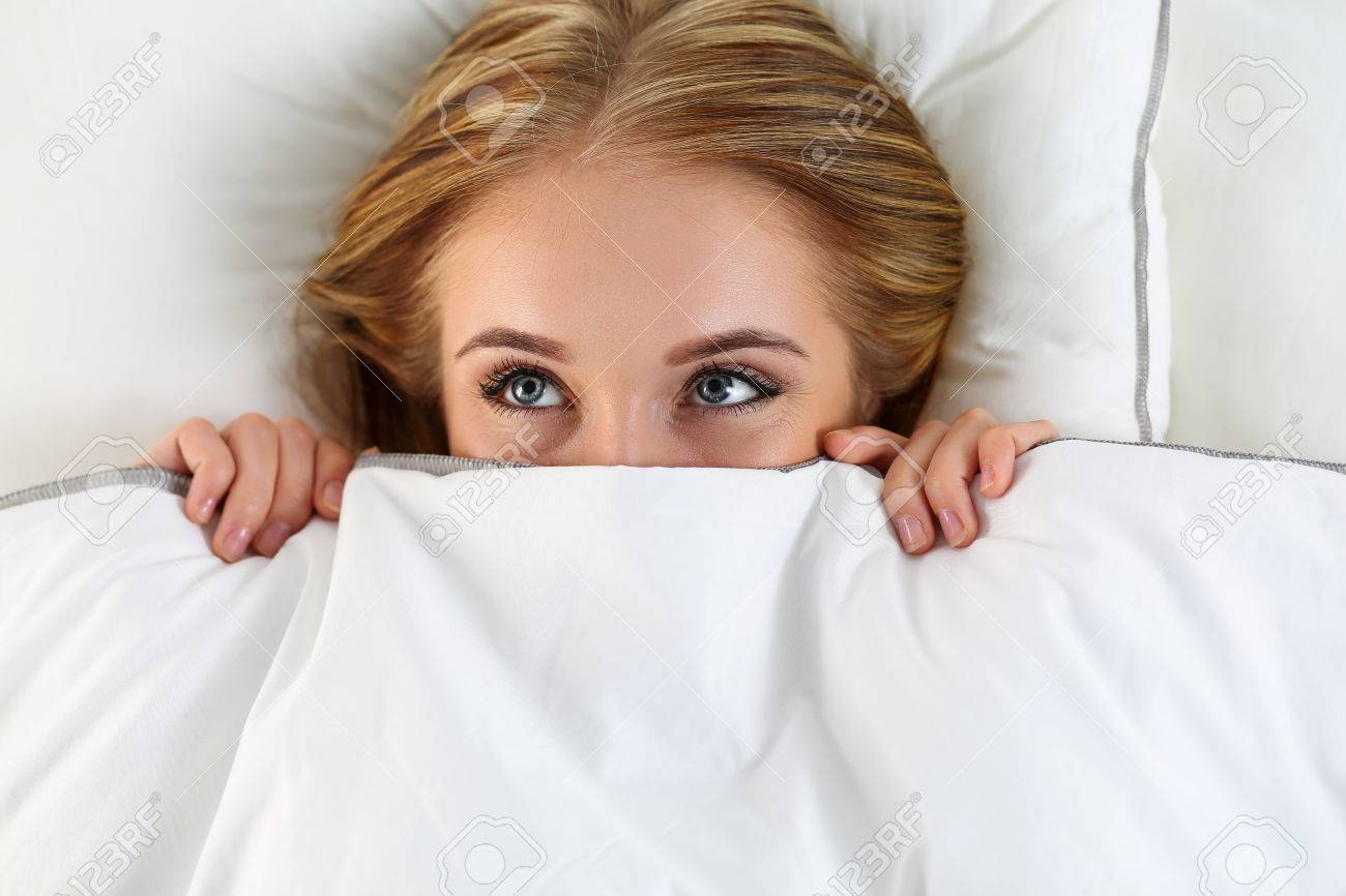 美しい金髪女性のカバーの下でベッドで横になっている顔を隠します。女性スパーキーの目のクローズ アップを見てします。浮気で、ロールプレイング  ゲーム、甘い夢は、奇妙な場所、恥、カジュアル セックスの概念をウェイク アップの写真素材・画像素材 Image 50988883