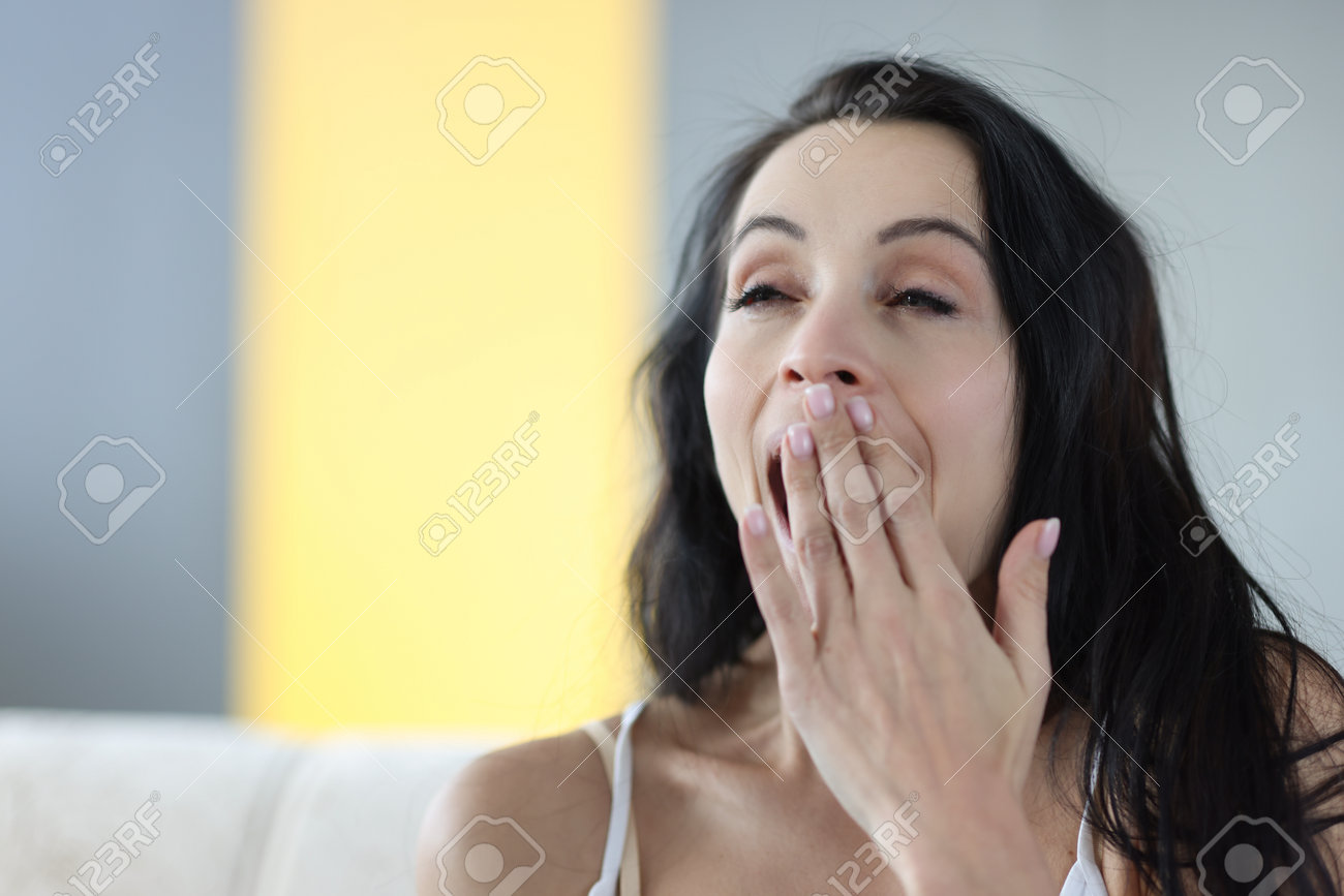 Portrait of young yawning brunette woman at home. Insomnia early awakening concept - 160544092 Portrait of young yawning brunette woman at home. Insomnia early awakening concept - 160544092