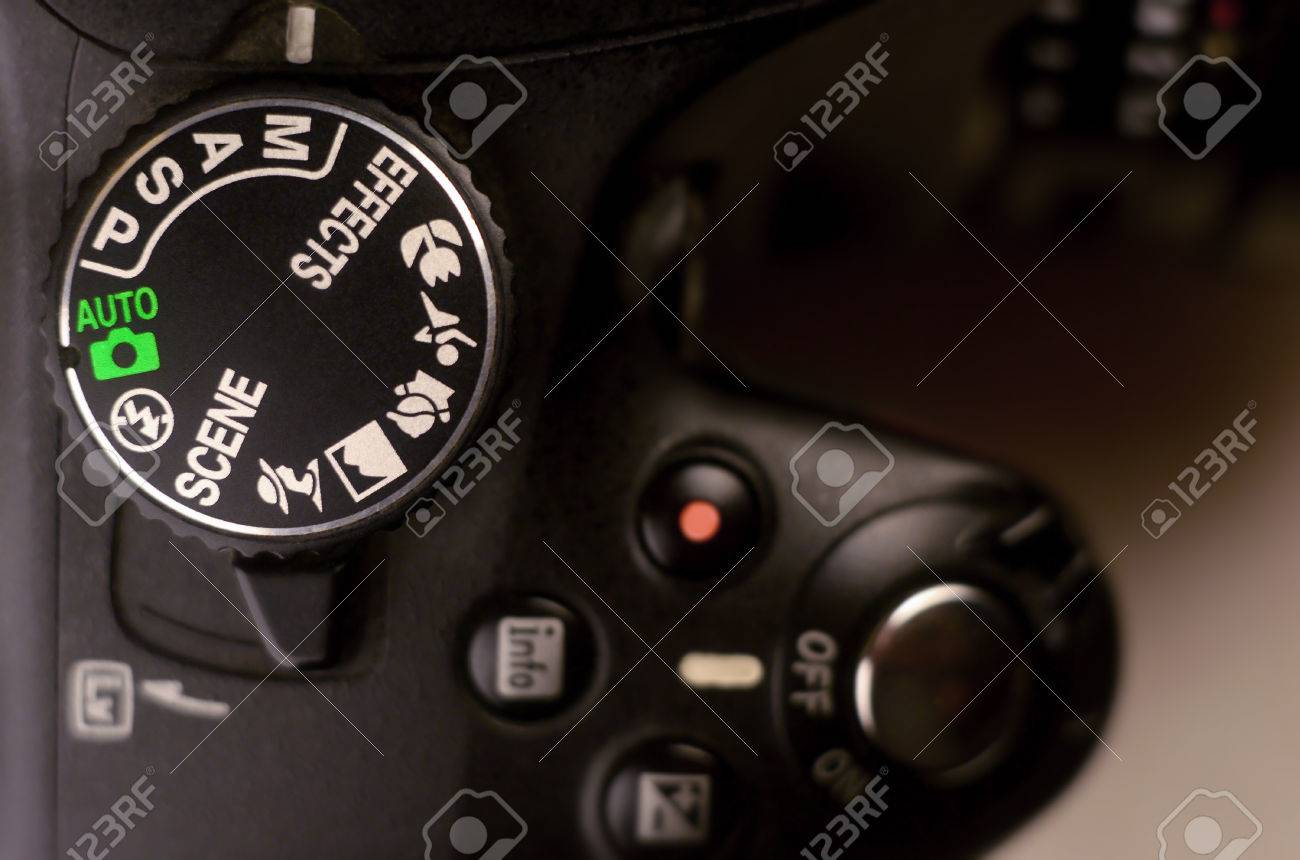 Close-up macro shot of a modern digital SLR camera. Detailed photo of black camera body with buttons to control and switch shooting modes - 71677214 Close-up macro shot of a modern digital SLR camera. Detailed photo of black camera body with buttons to control and switch shooting modes - 71677214