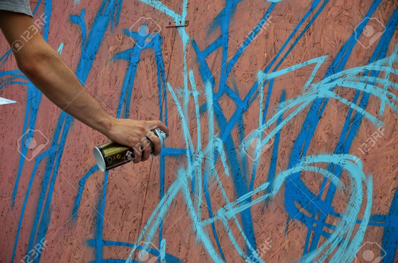 スプレーで手を壁に新しい落書きを描画することができます 木製の壁のクローズ アップにらくがきのプロセスの写真 ストリート アートや違法な破壊行為の概念 の写真素材 画像素材 Image