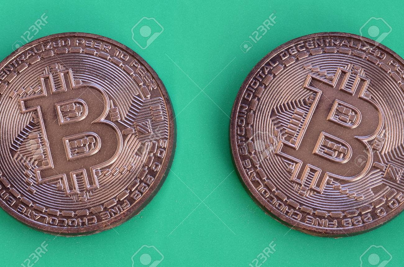 物理的なビットコインの形で2つのチョコレート製品は、緑のプラスチックの背景にあります。食用形式の暗号通貨のモデルの写真素材・画像素材 Image  96140108