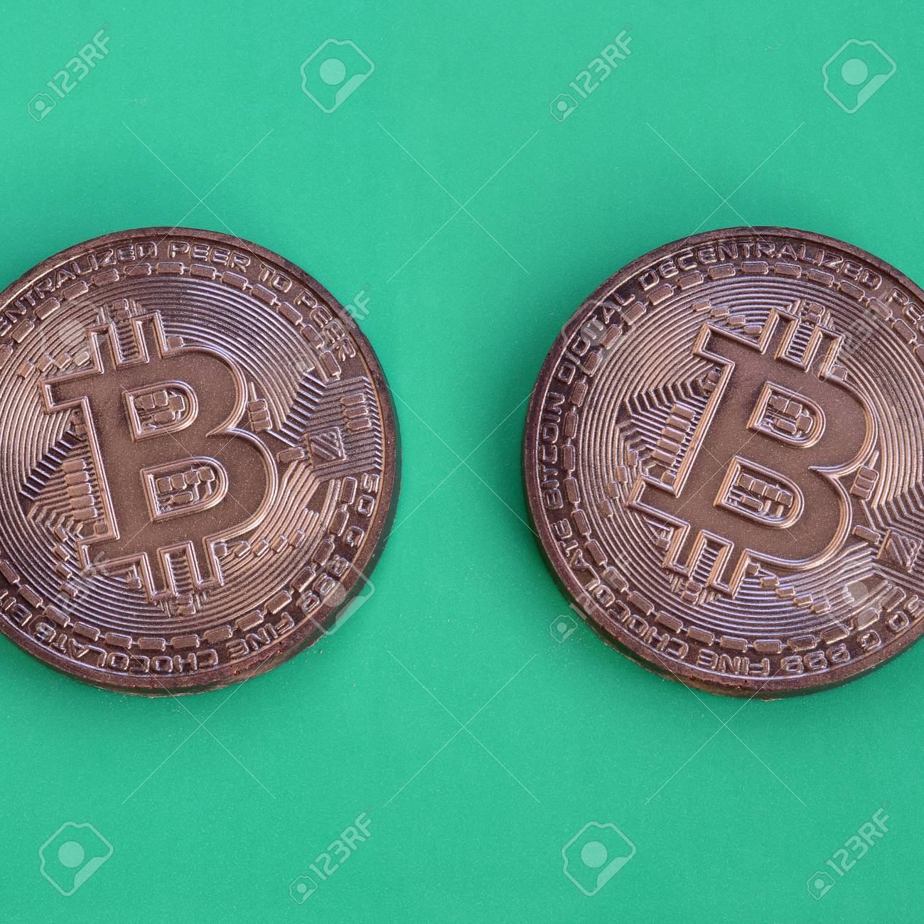 물리적 비트 코인 형태의 두 초콜릿 제품은 녹색 플라스틱 배경에 놓여 있습니다. 식용 형태의 암호화 통화 모델 로열티 무료 사진,  그림, 이미지 그리고 스톡포토그래피. Image 96140194