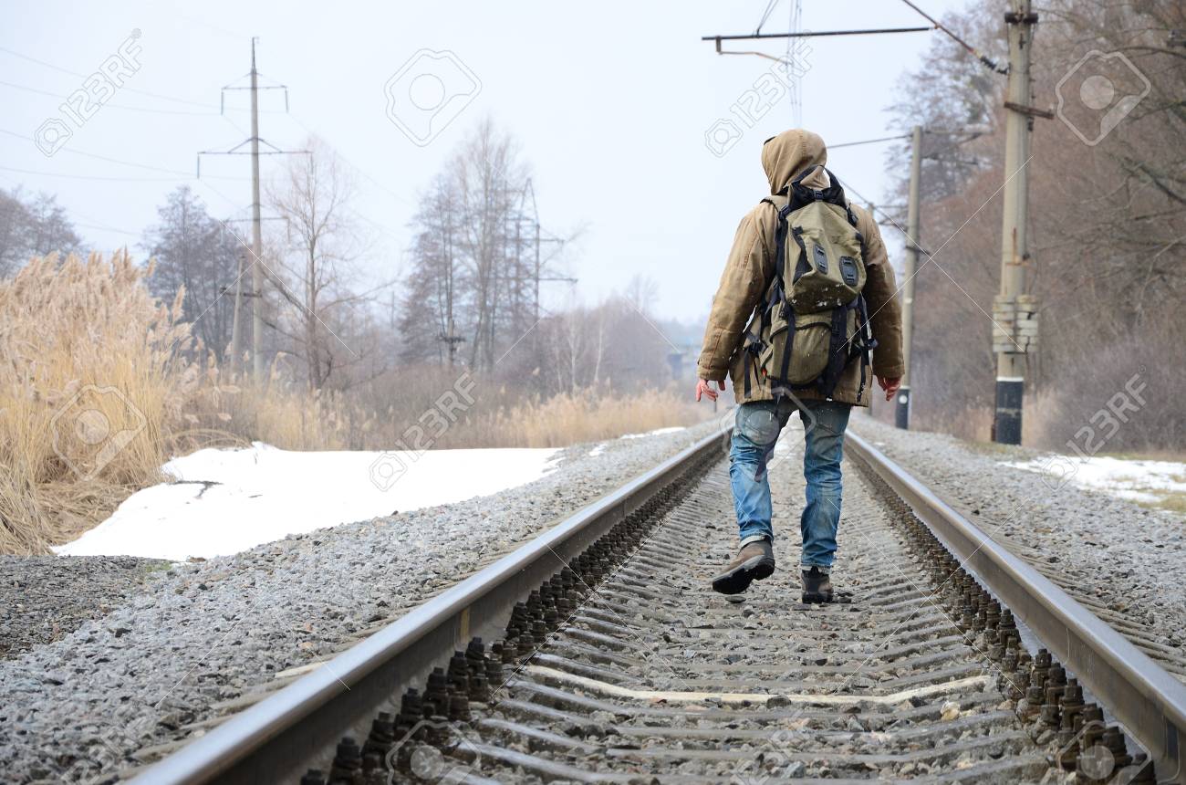 大きなバックパックを持つ男は 冬のシーズン中に線路上を進みます の写真素材 画像素材 Image