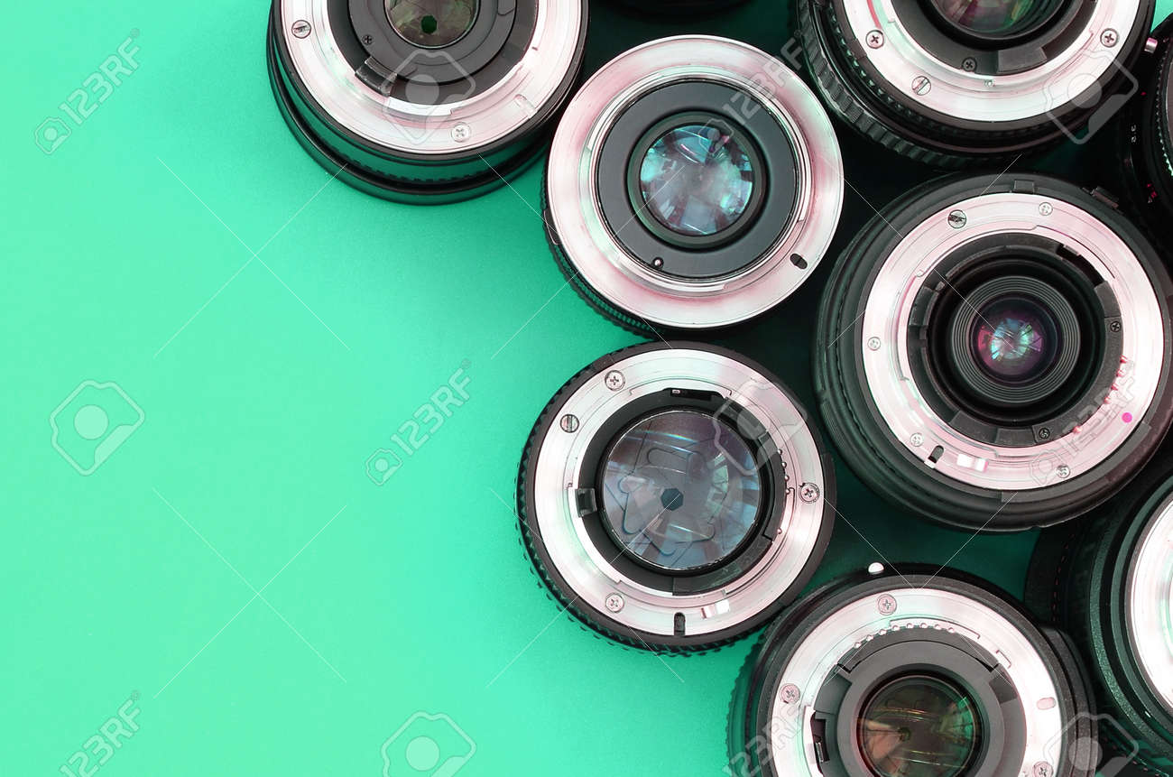 Several photographic lenses lie on a bright turquoise background. Space for text - 167450070 Several photographic lenses lie on a bright turquoise background. Space for text - 167450070