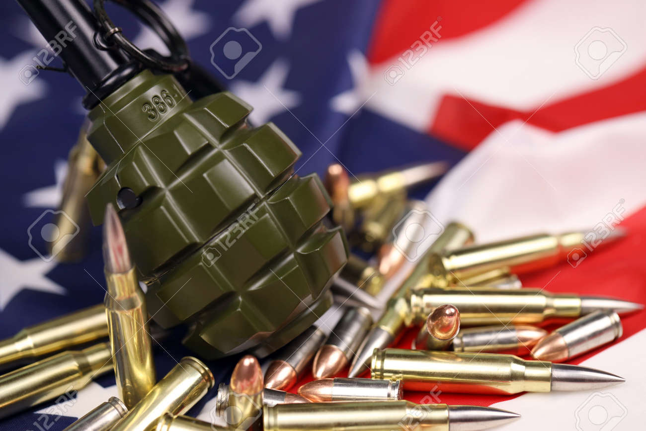 F1フラググレネードと米国旗の多くの黄色い弾丸とカートリッジ。米国の  