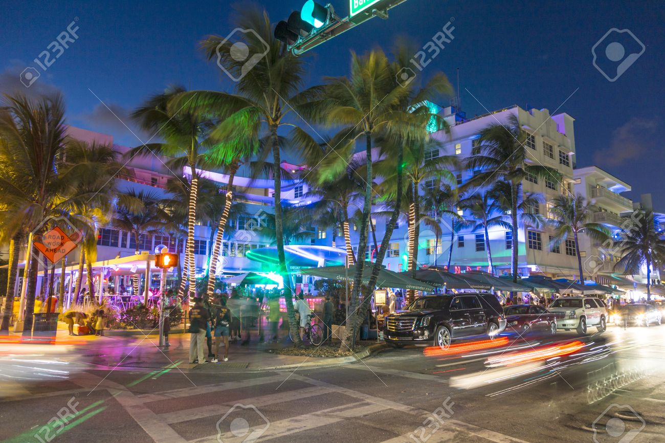 MIAMI, USA - AUG 23, 2014: Palm trees and art deco hotels at Ocean Drive by night. The road is the main thoroughfare through South Beach in Miami, USA. - 32895691 MIAMI, USA - AUG 23, 2014: Palm trees and art deco hotels at Ocean Drive by night. The road is the main thoroughfare through South Beach in Miami, USA. - 32895691