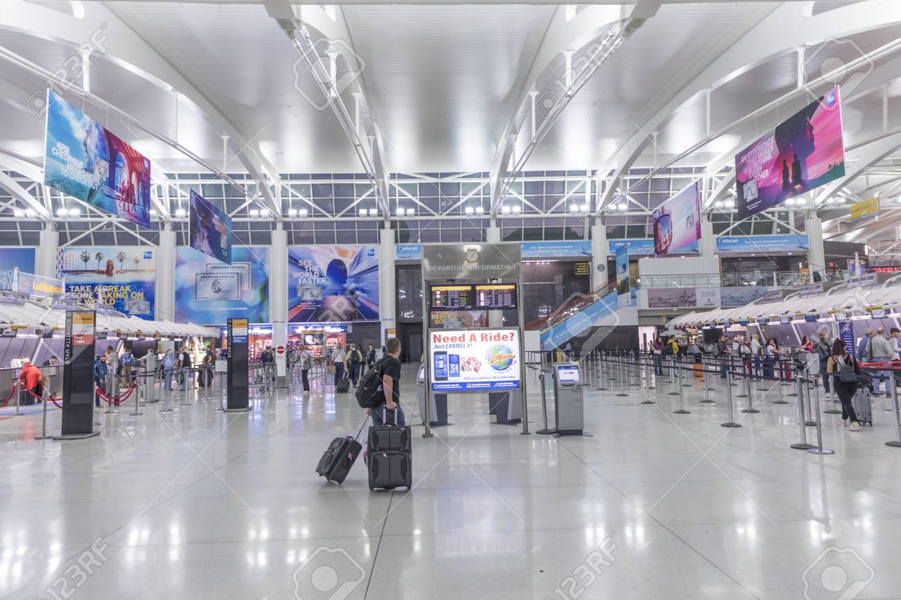 NEW YORK, USA - OCT 7, 2017: people ready for check in at Terminal 4 in JFK airport, New York. In 1963 the airport was rededicated John F. Kennedy International Airport. - 87088628 NEW YORK, USA - OCT 7, 2017: people ready for check in at Terminal 4 in JFK airport, New York. In 1963 the airport was rededicated John F. Kennedy International Airport. - 87088628