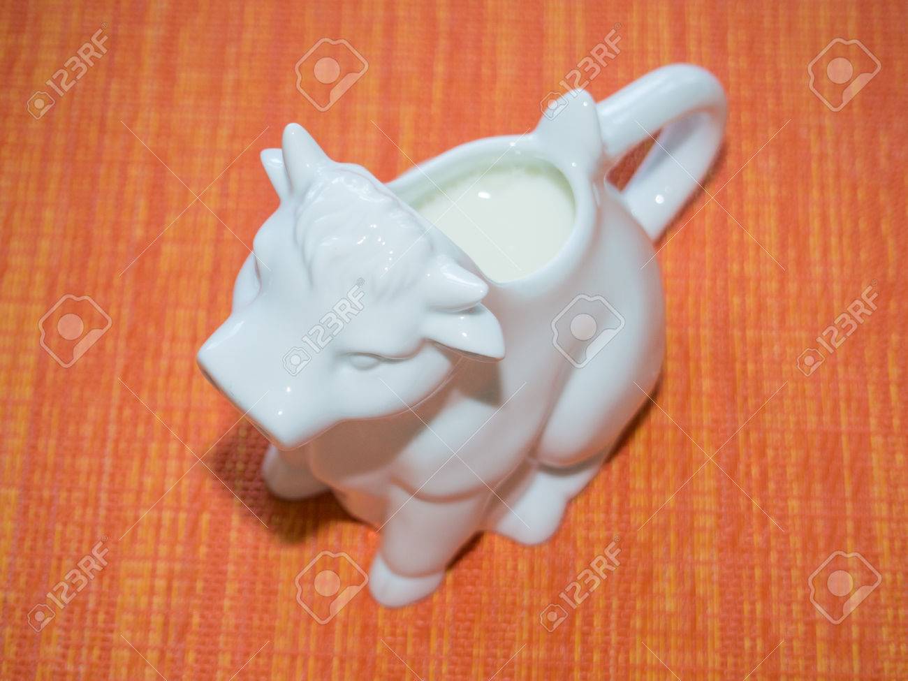 ハンドルと液体の尾を持つ牛のような形をしている磁器のクリームやミルク ピッチャーは 牛の口から注ぐ の写真素材 画像素材 Image