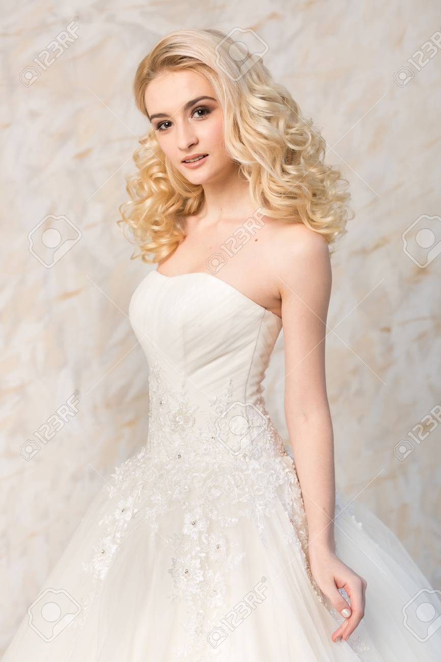 A Gorgeous Smiling Blonde Bride With Beautiful Curly Hair In