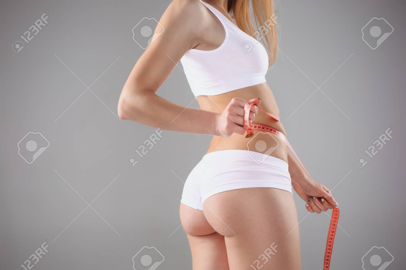 Beautiful girl in white lingerie holding blue meter measuring perfect shape of her beautiful body on a white background - 57281485 Beautiful girl in white lingerie holding blue meter measuring perfect shape of her beautiful body on a white background - 57281485