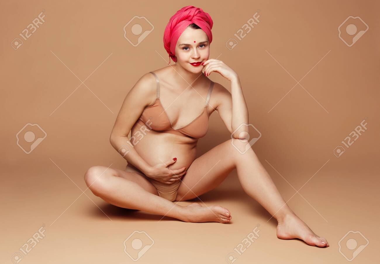 親子　ヌード　画像 茶色の背景にポーズをとって若い美しい妊婦。スタジオに座っている幸せな白人女性モデル。妊娠、親、マタニティ、母の日、親子関係、家族の概念。の写真素材・画像素材  Image 120532578