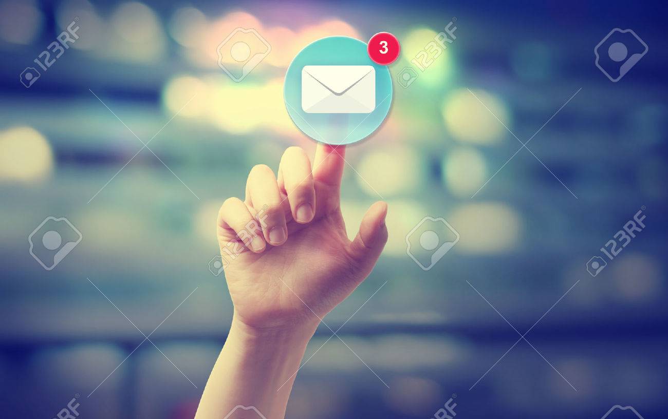 Hand pressing an email icon on blurred cityscape background - 43317885 Hand pressing an email icon on blurred cityscape background - 43317885