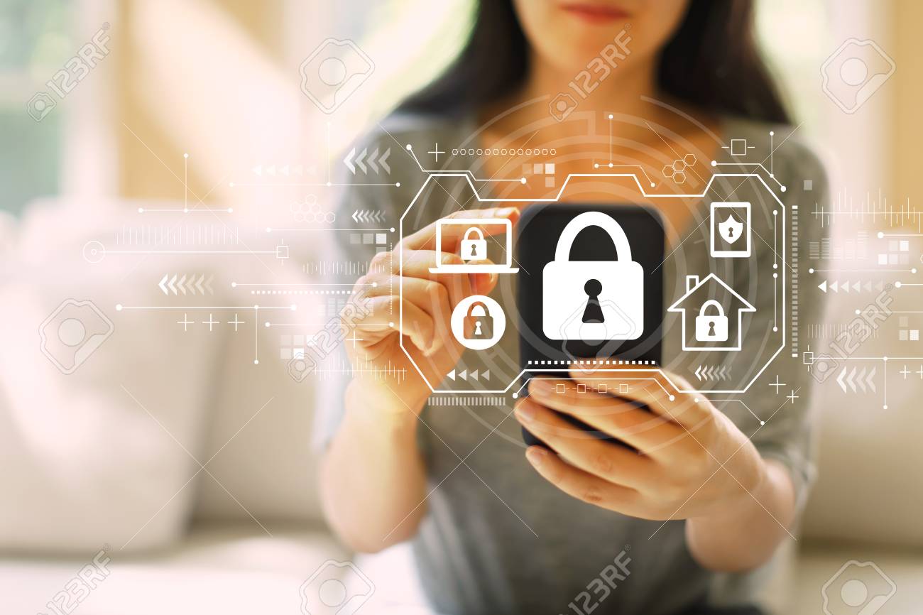 Security theme with woman using her smartphone in a living room - 121338449 Security theme with woman using her smartphone in a living room - 121338449