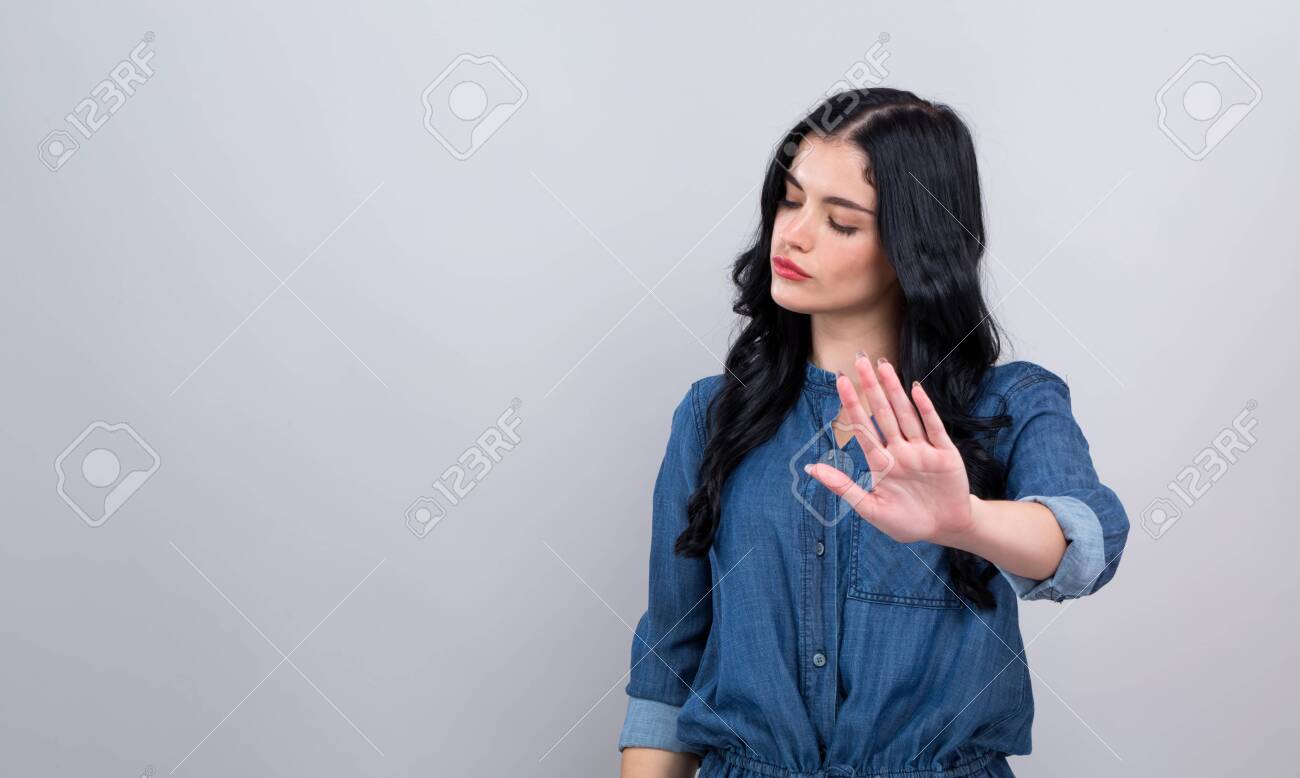 Young woman making a rejection pose on a gray background - 132178525 Young woman making a rejection pose on a gray background - 132178525