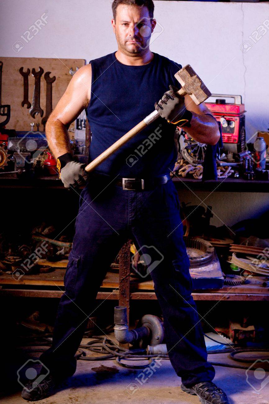 View of a garage mechanic man holding a big hammer. - 10544491
