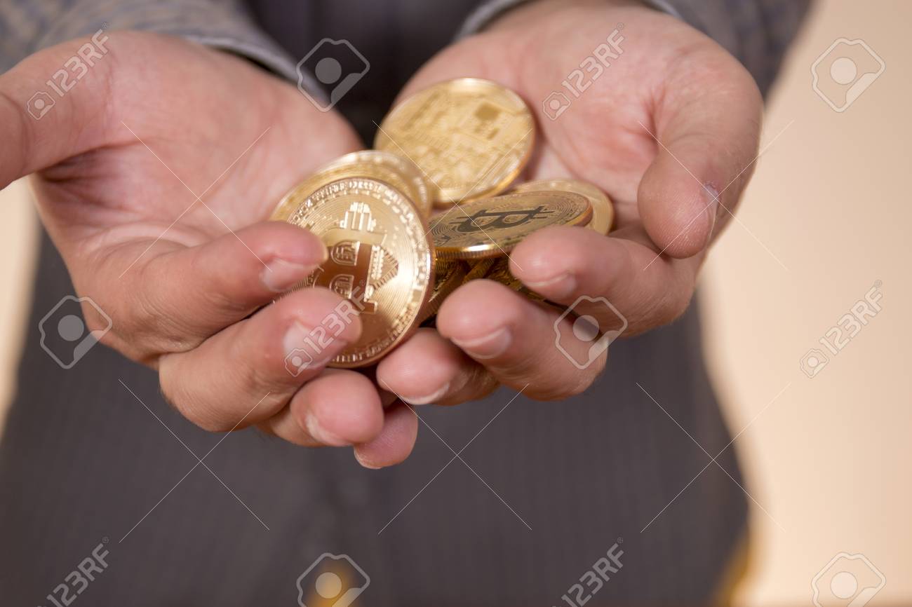 디지털 암호화폐인 비트코인을 잔뜩 들고 있는 손 로열티 무료 사진, 그림, 이미지 그리고 스톡포토그래피. Image 97593309