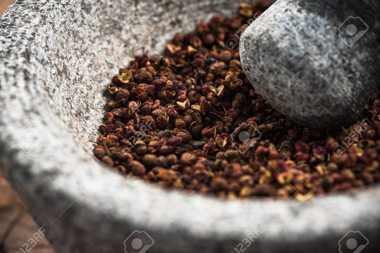 Timut sihuan pepper seeds in granite pestle or mortar. - 112989827 Timut sihuan pepper seeds in granite pestle or mortar. - 112989827