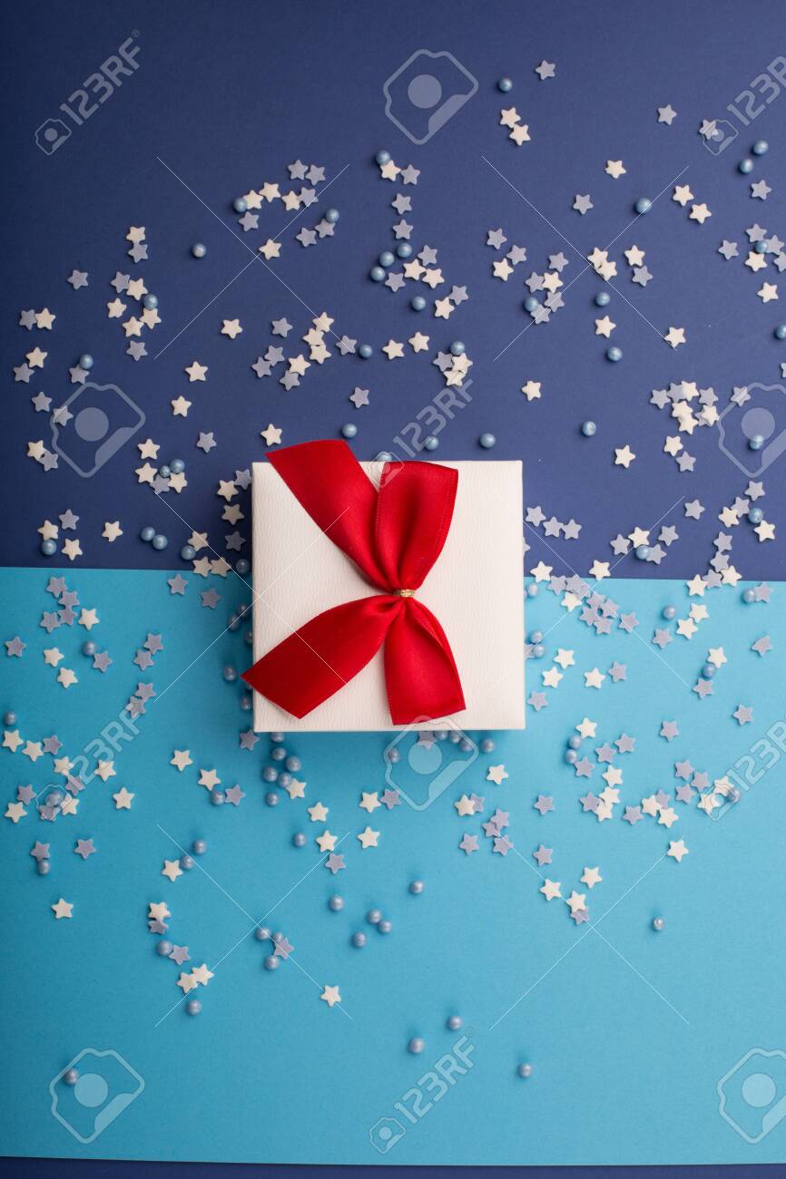 Happy Valentine's Day card with gift, small stars and white gift with red bow on classic blue background. Holiday time concept. Mockup template. Top view - 137251104 Happy Valentine's Day card with gift, small stars and white gift with red bow on classic blue background. Holiday time concept. Mockup template. Top view - 137251104