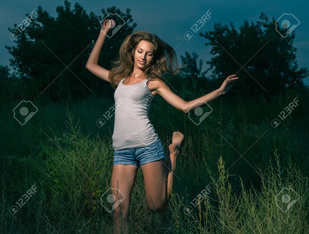 かわいい女性 Weared タンクトップと傾くショート パンツ アウトドア幸せな女の子屋外ジャンプ の写真素材 画像素材 Image