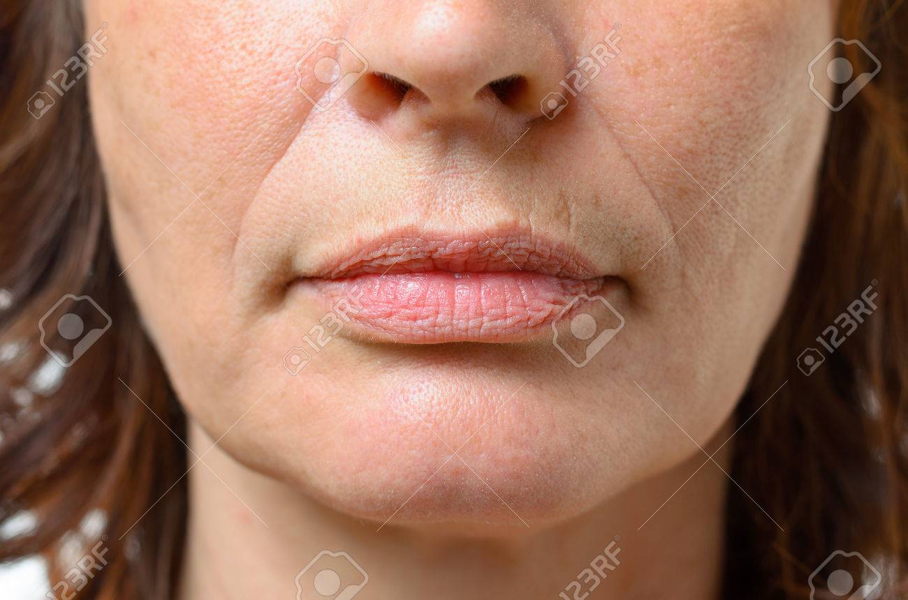 Closeup on the mouth of a middle-aged brunette woman with her mouth closed and a serious expression - 59848626 Closeup on the mouth of a middle-aged brunette woman with her mouth closed and a serious expression - 59848626