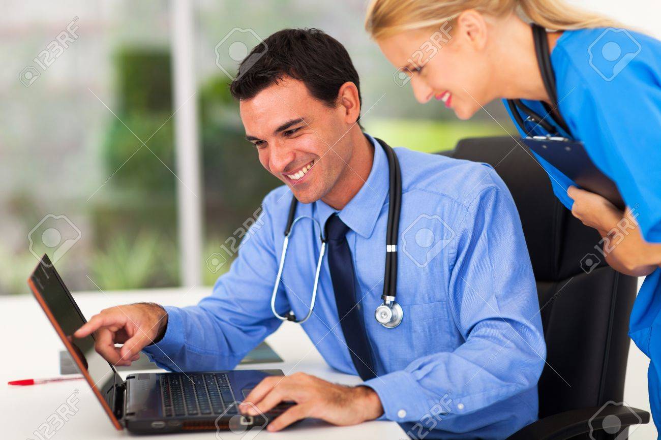 happy male doctor and medical assistant looking at computer stock looking for medical assistant