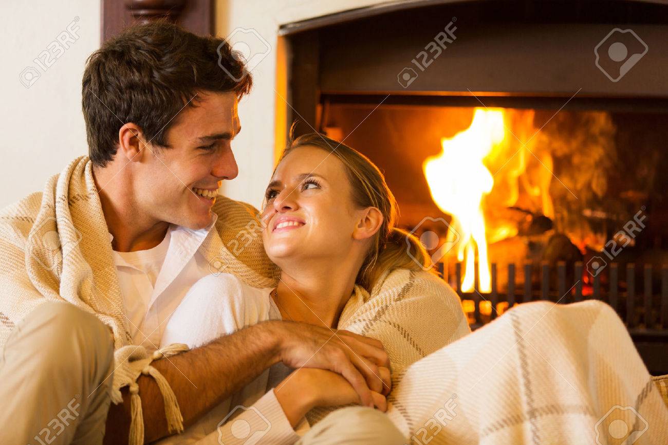 素敵なカップルは 暖炉のそばでロマンチックな夜を過ごす の写真素材 画像素材 Image