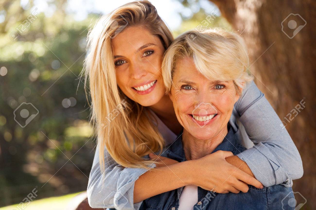 loving daughter hugging middle aged mother outdoors stock photo