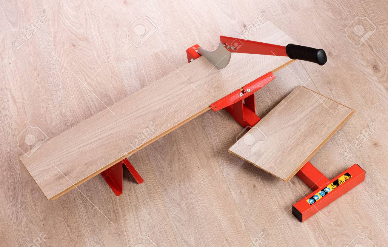 Red Tool For Cutting Laminate On A Floor Stock Photo Red Tool For Cutting Laminate On A Floor Stock Photo 55505537