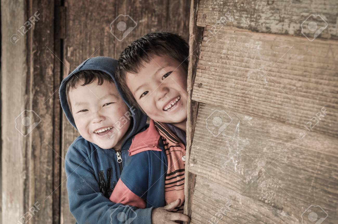 Dorjeling アルナーチャル プラデーシュ州 12 年 3 月頃 二人の笑みを浮かべて少年を Dorjeling アルナーチャル プラデーシュ州の学校の壁の後ろにおずおずと非表示 ドキュメンタリー編集 の写真素材 画像素材 Image