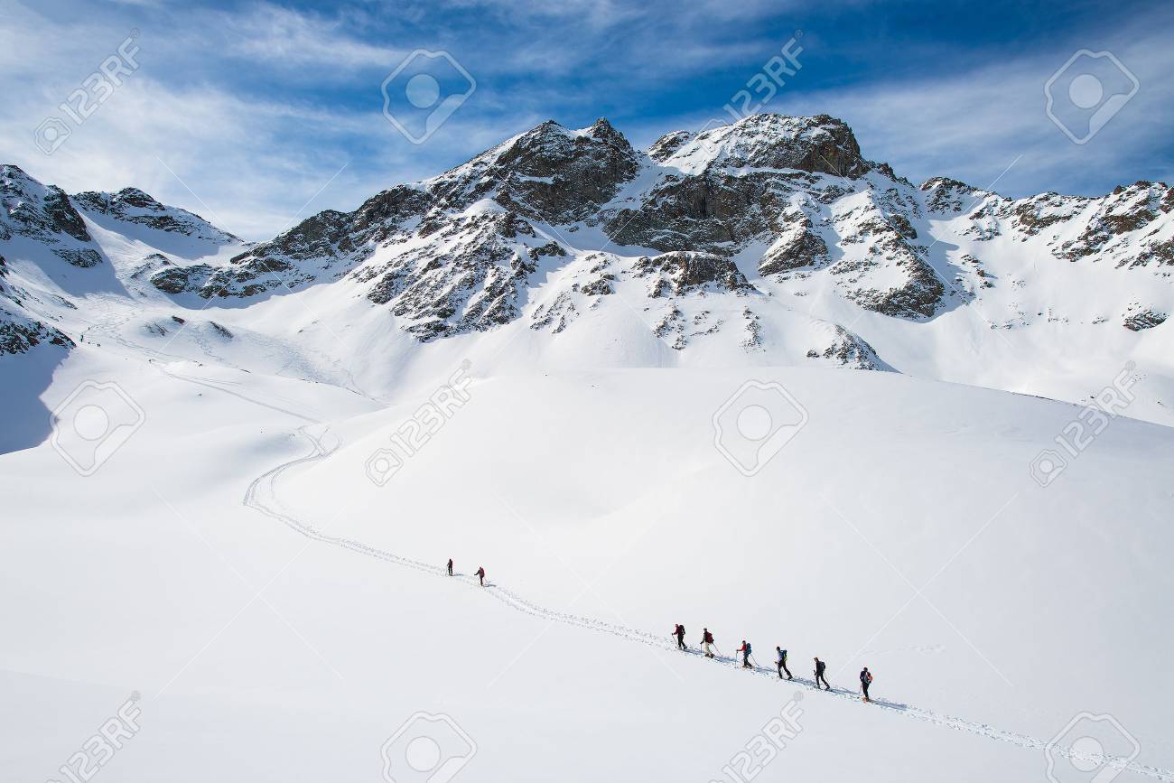 Group of climbers roped to the summit in the winter - 55342542 Group of climbers roped to the summit in the winter - 55342542