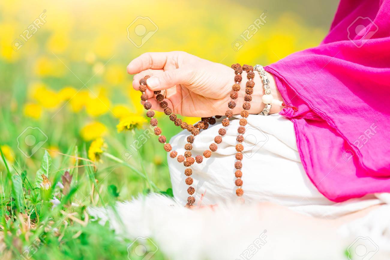 Use of Mala with mantras during a yoga practice flourished in nature - 76066088 Use of Mala with mantras during a yoga practice flourished in nature - 76066088