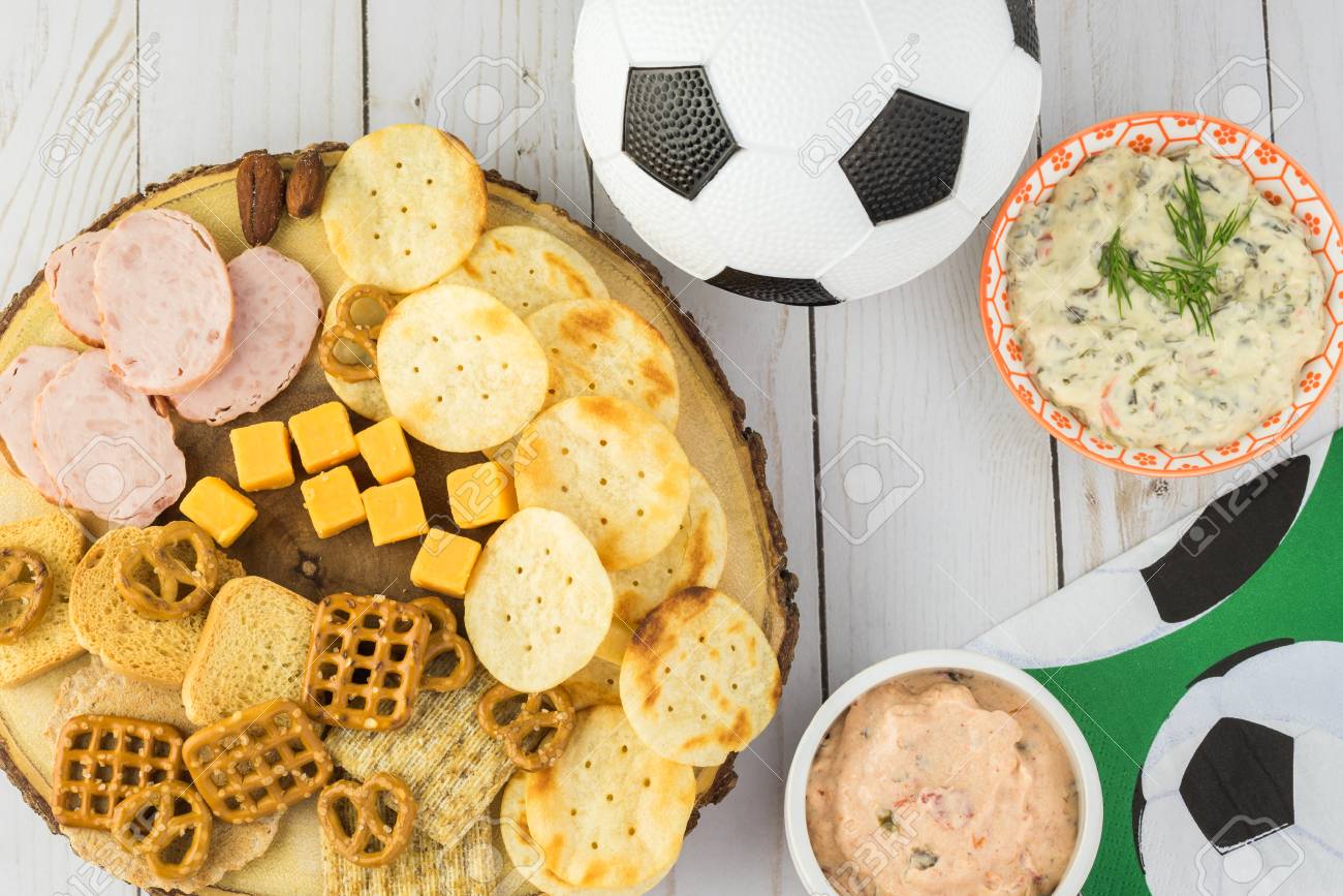 top view of party table with variety of snacks and dips for soccer