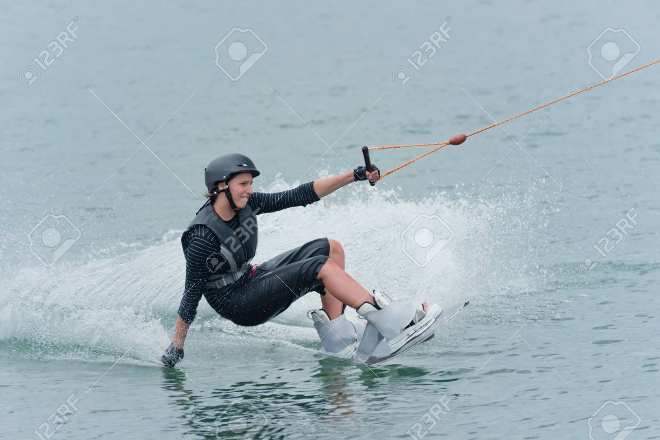 Woman Touching The Water With One Hand And Holding A Rope With