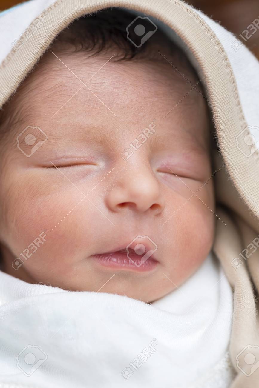 生まれたばかりの赤ちゃん男の子顔彼の毛布で寝ています の写真素材 画像素材 Image