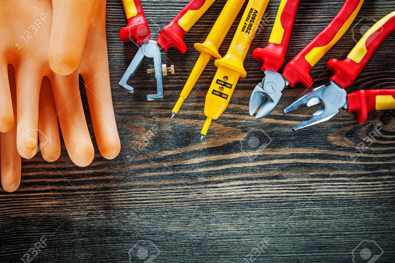 Guantes Aislantes Aisladores Del Aislamiento Del Eléctrico Que Cortan Alicates De Las Pinzas En El Tablero De Madera. Fotos, Retratos, Imágenes Fotografía De Archivo Libres De Derecho. Image