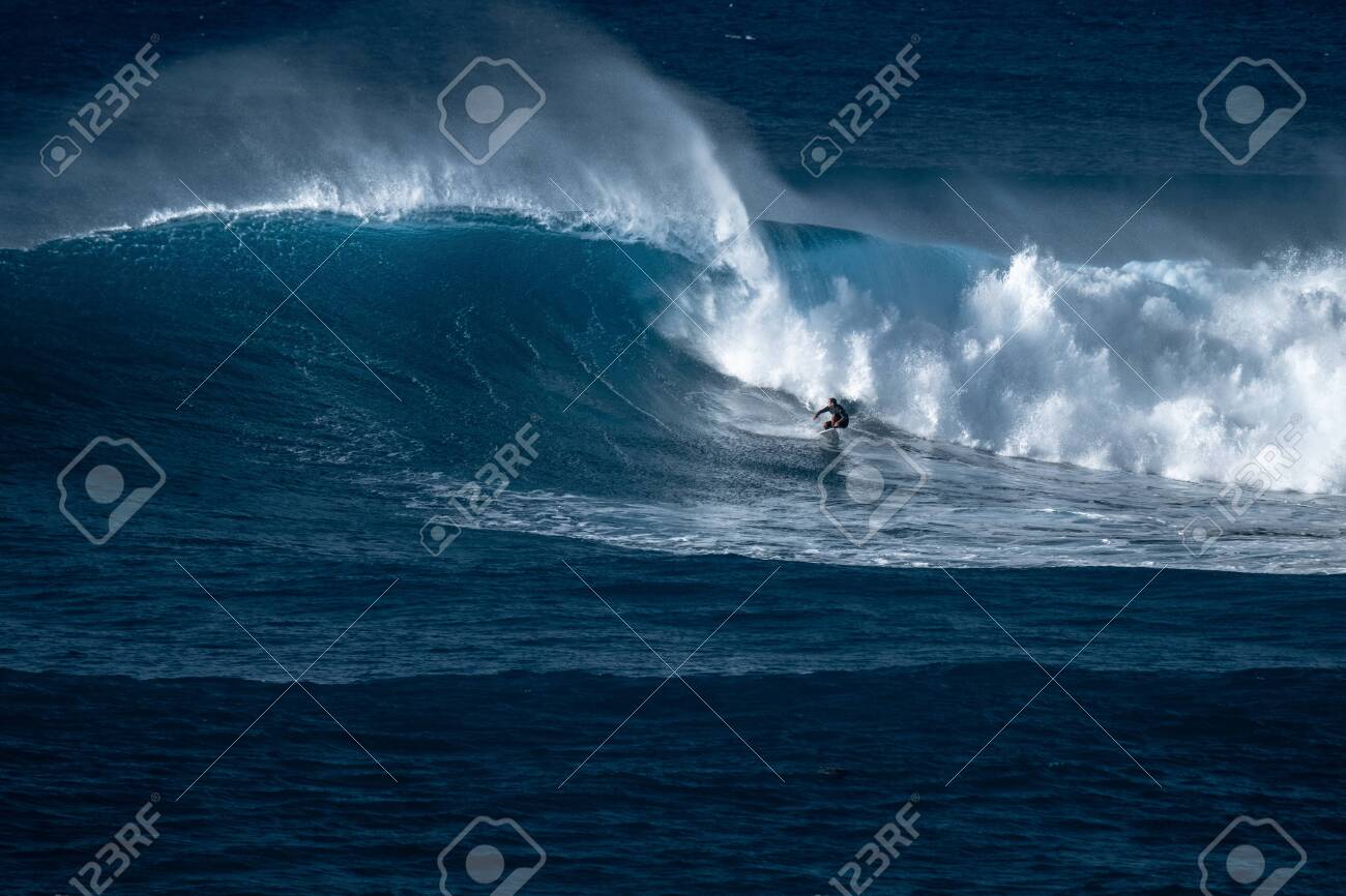Surfer rides giant wave at the famous Waimea Bay surf spot located on the North Shore of Oahu in Hawaii - 125488299 Surfer rides giant wave at the famous Waimea Bay surf spot located on the North Shore of Oahu in Hawaii - 125488299