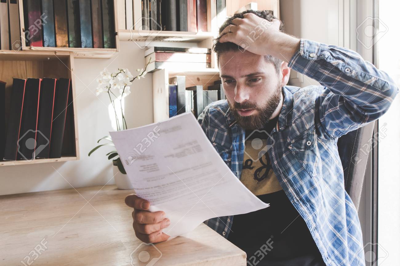 Worried Man Working And Reading A Letter With Bad News Stock Photo, Picture And Royalty Free Image. Image 98541564.