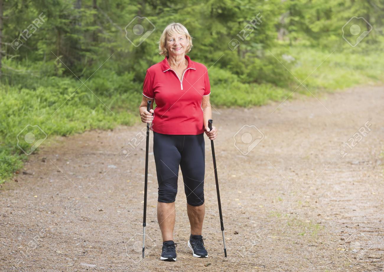 Front View Of A Happy Active Senior Woman Nordic Walking In The