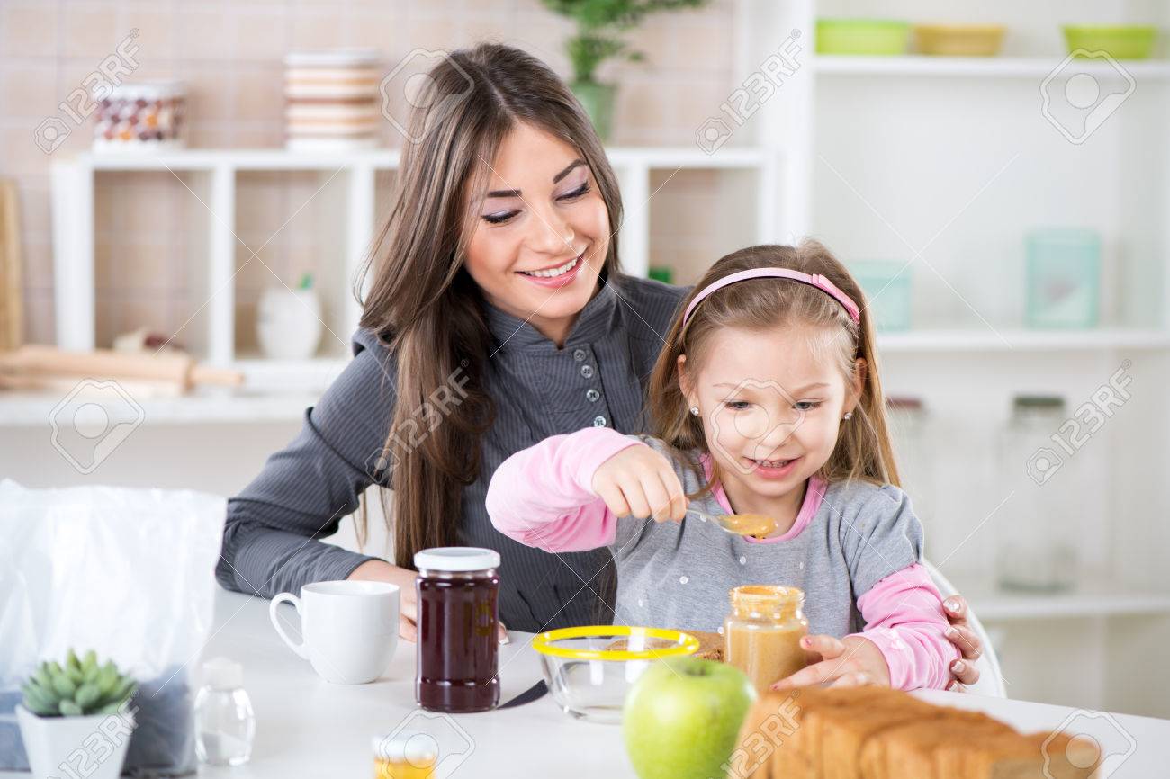 Nettes Kleines Madchen In Der Mutter Schoss Und Schmieren Erdnussbutter Auf Brot Lizenzfreie Fotos Bilder Und Stock Fotografie Image 26134647