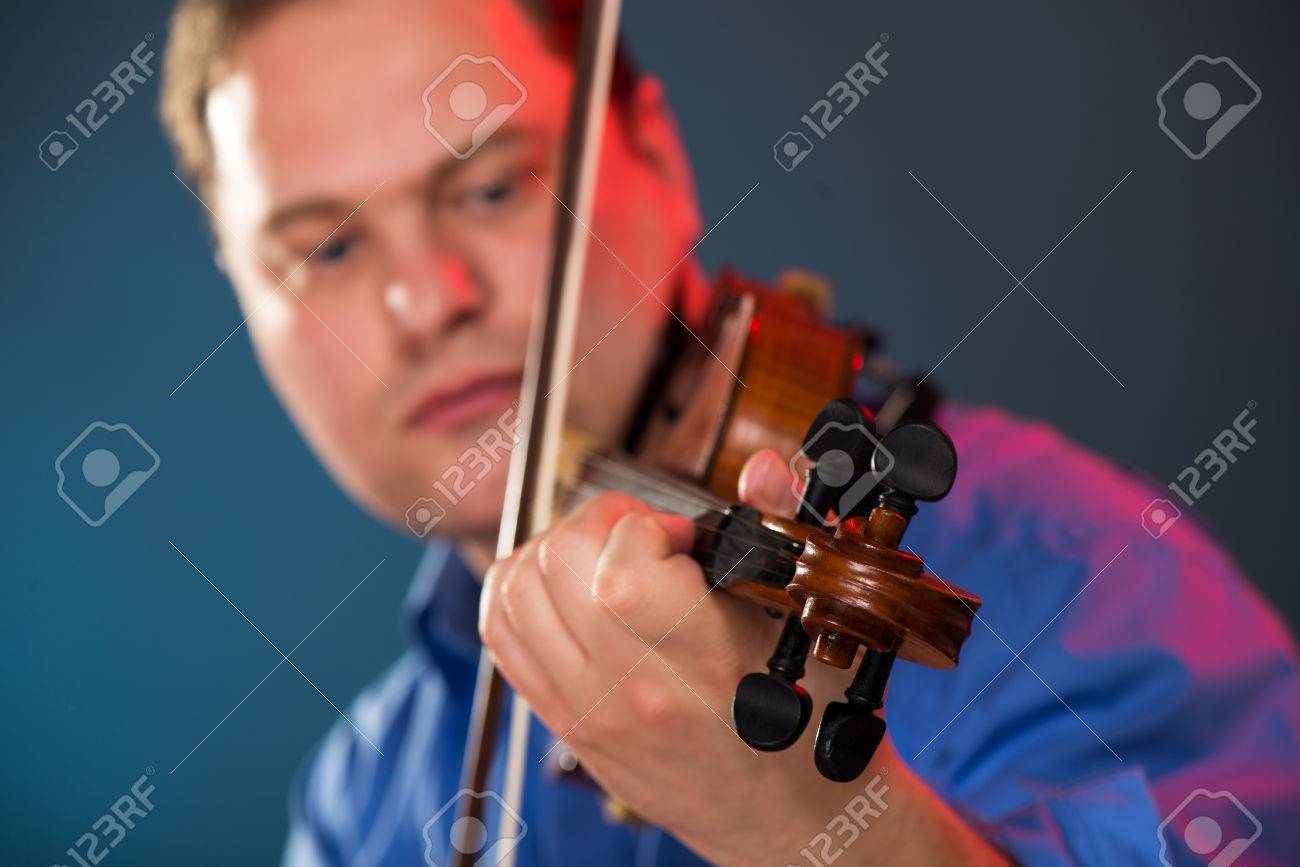 Close-up of violin in the hands of the violin virtuoso with a face out of focus. - 35762280 Close-up of violin in the hands of the violin virtuoso with a face out of focus. - 35762280