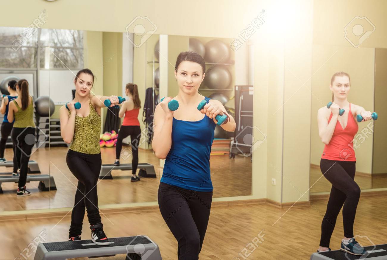 group of women making step aerobics in the fitness class stock photo