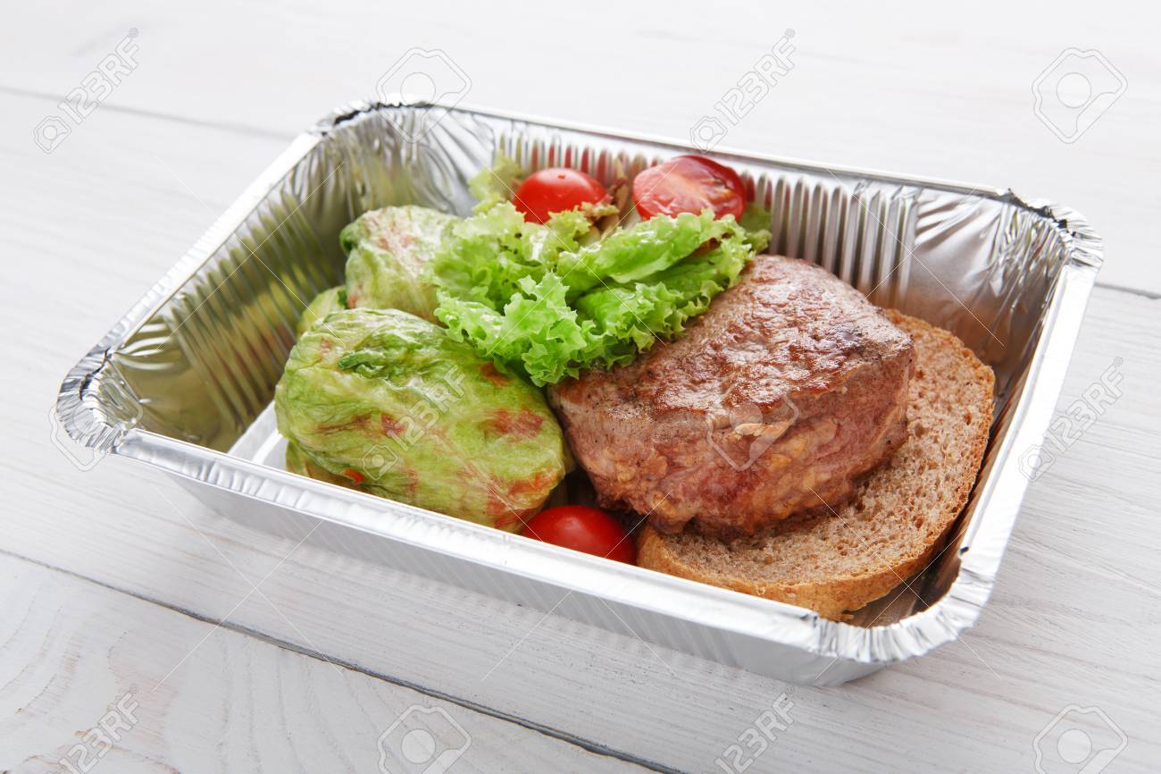 箔のボックスの健康レストラン食品配達 創作料理 緑茶色のパンの仔牛のステーキとロール キャベツの煮込み 牛肉と野菜のミニトマト レストラン料理を離れてクローズ アップ の写真素材 画像素材 Image