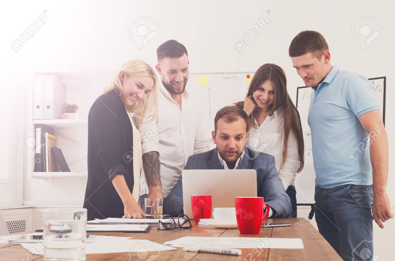 幸せなビジネスの人々 は オフィスでノート パソコンに近い笑います 女性の成功した企業チームと男性が同僚の冗談し 仕事で一緒に楽しい時を過します インターネット開発コンセプト の写真素材 画像素材 Image