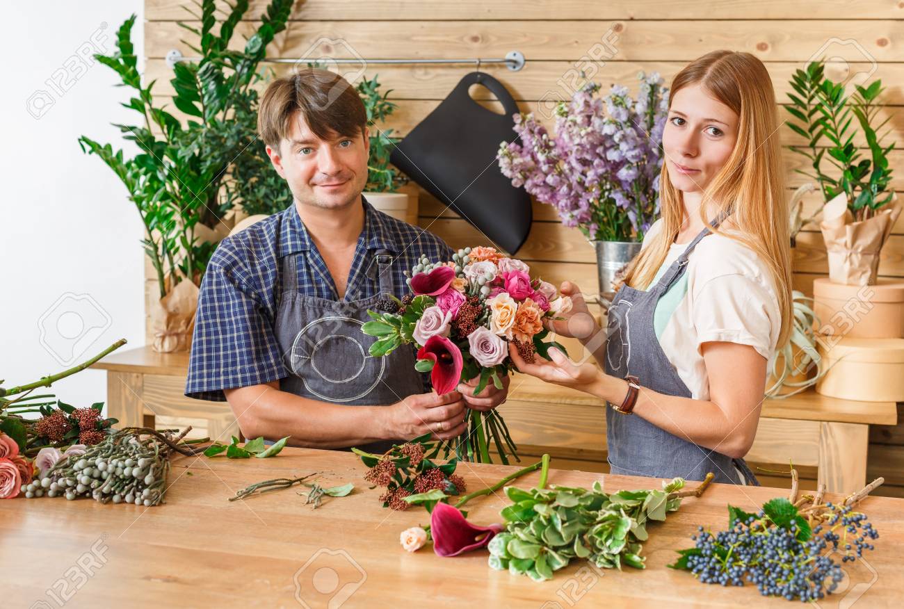 中小企業です 男性と女性の花屋フラワー ショップでバラの花束を作るします 男性オーナーと女性の助手花デザイン スタジオ装飾やアレンジを作るします 花の配達 注文の作成 の写真素材 画像素材 Image
