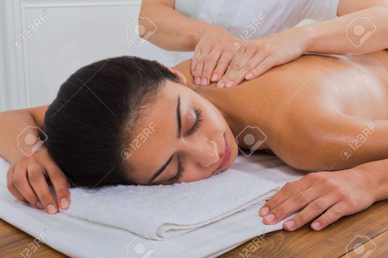 スパのマッサージ療法 マッサージ師は オイル マッサージを美しいインドの女の子美容キャビネットまたは美容院にバックアップの体を作る の写真素材 画像素材 Image