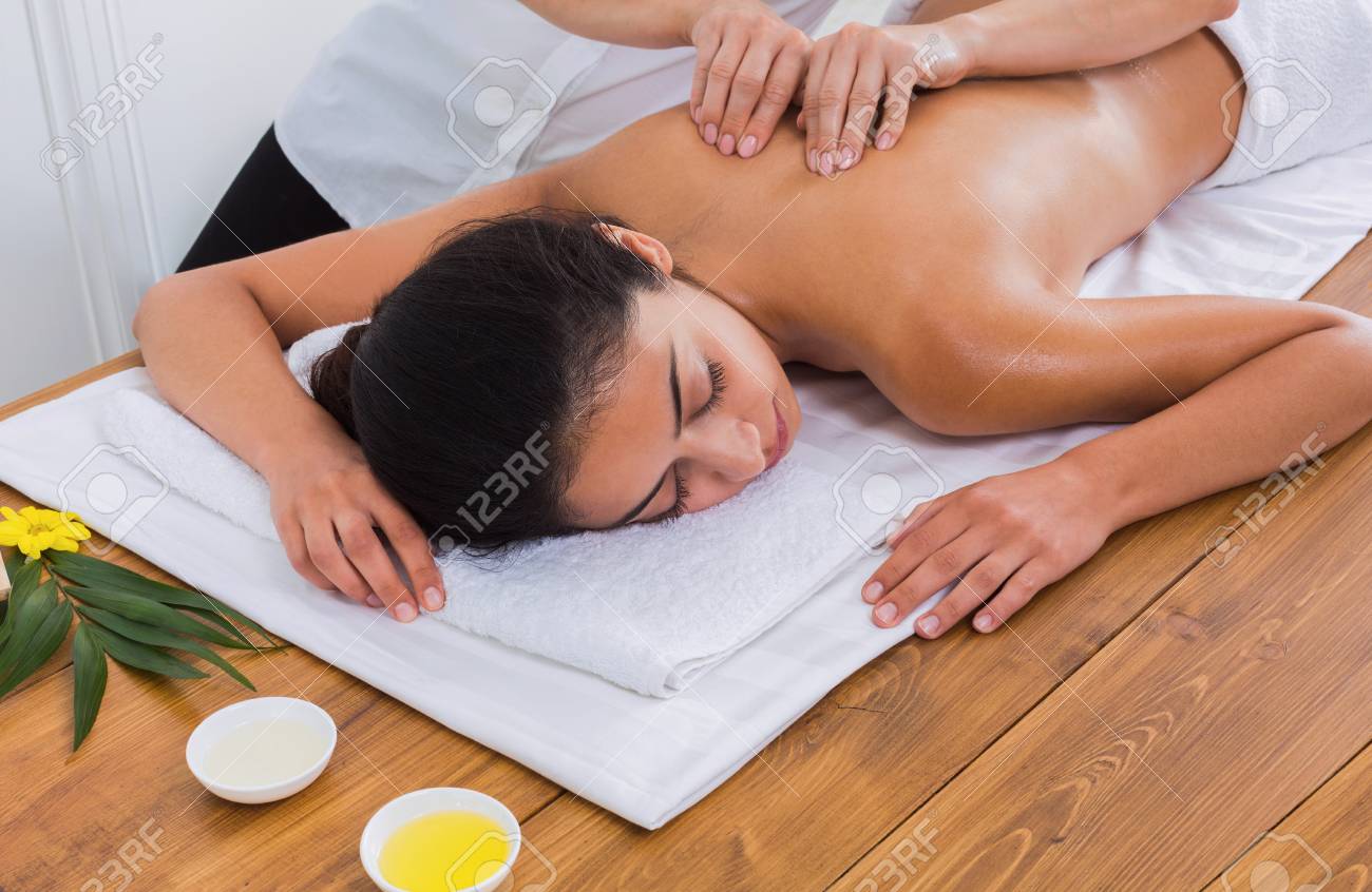 スパにはマッサージ療法です マッサージ師は美容キャビネットでインド美女とボディオイル マッサージや美容室を作る の写真素材 画像素材 Image