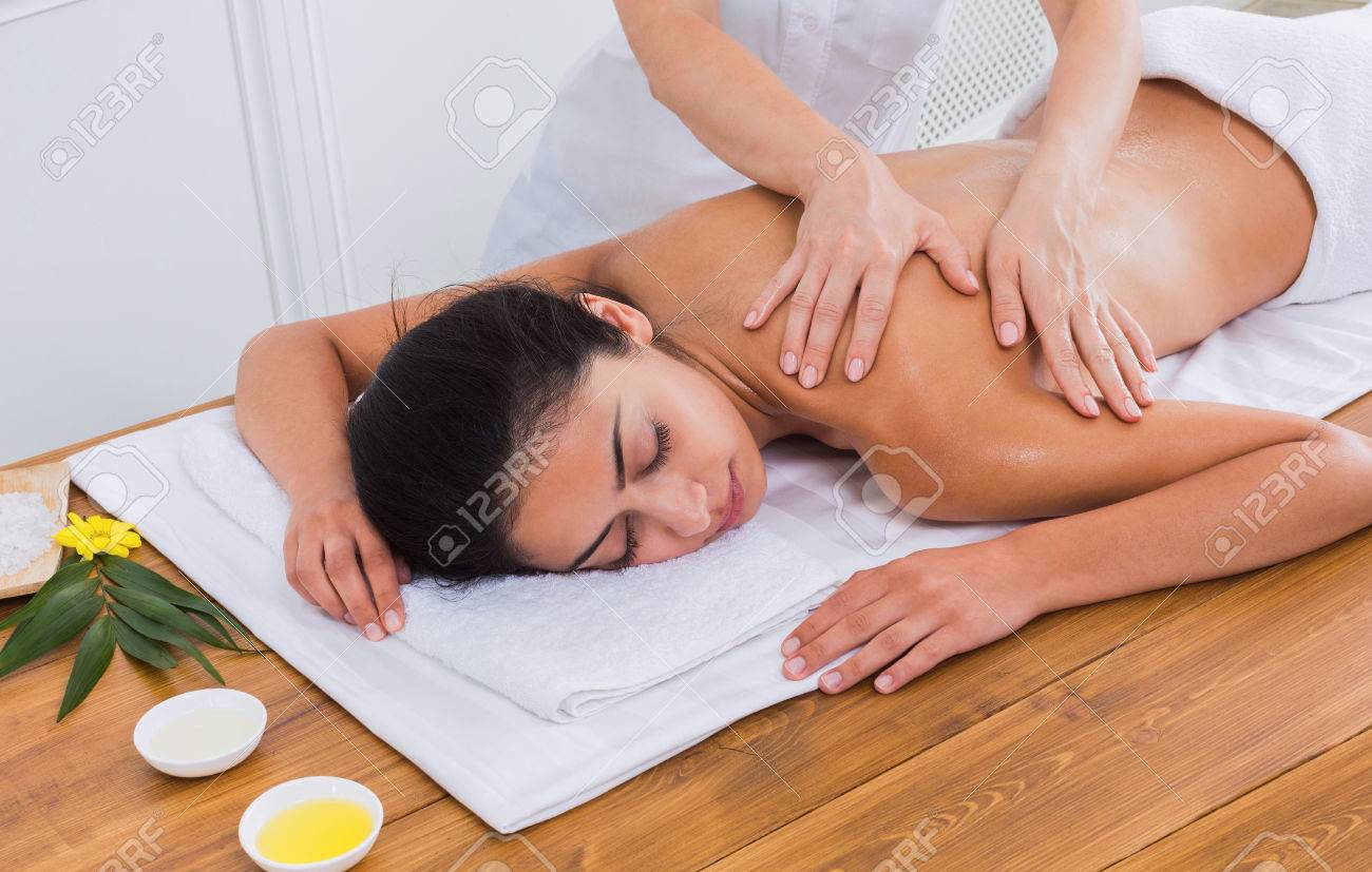 スパにはマッサージ療法です マッサージ師は美容キャビネットでインド美女とボディオイル マッサージや美容室を作る の写真素材 画像素材 Image