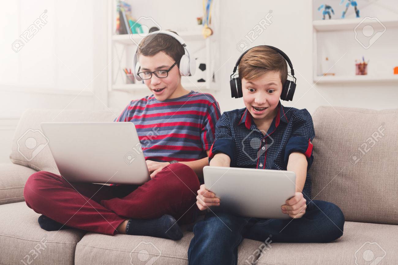 Teenage Couple With Headphone Play Game Online At Home Computer. Stock Photo, Picture and Royalty Free Image. Image 172632258.