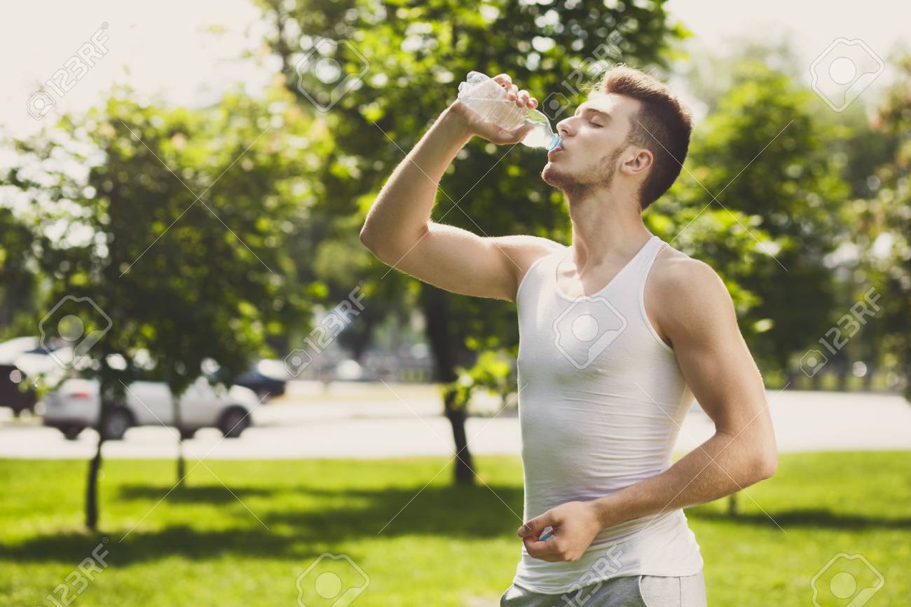 Young Sport Man Drinking Water After Training. Fitness Guy Holding Plastic  Bottle, Having Rest After Workout In Park, Healthy Lifestyle Concept Stock  Photo, Picture and Royalty Free Image. Image 94801470., image size:1300x866
