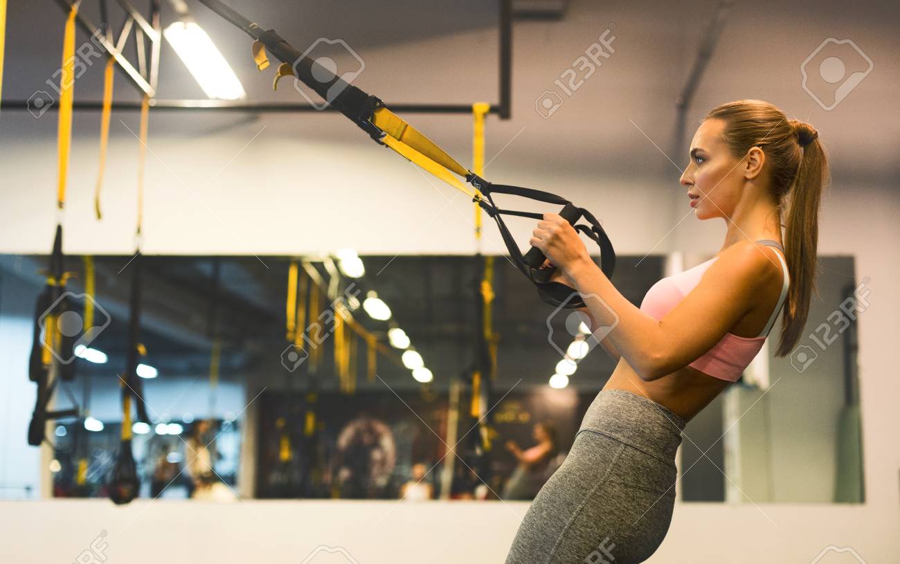 Fitness Woman Training With Trx Fitness Straps, Suspension Exercising In  Gym, Side View, Copy Space Stock Photo, Picture and Royalty Free Image.  Image 115154213.